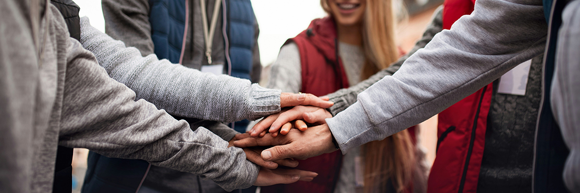 Group of people with hands placed one on top of the other