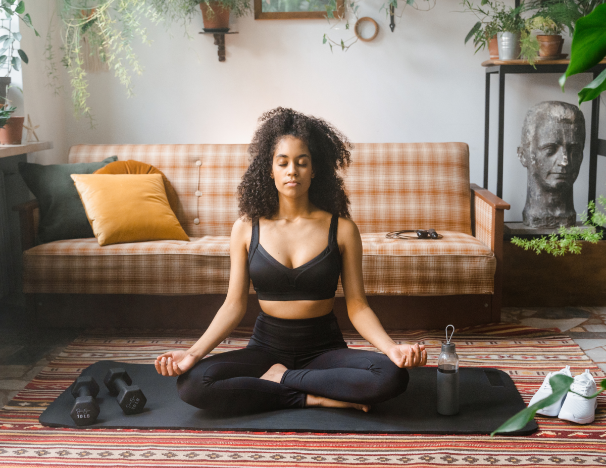 A Female meditating in the middle of a peaceful living room.